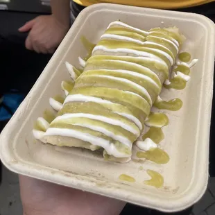 Tamale topped with green salsa and sour cream