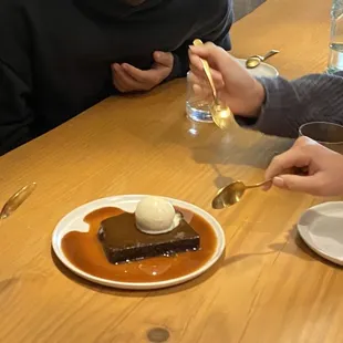 Sticky toffee pudding with burnt milk gelato and butterscotch sauce. Beautiful cutlery and dishware.