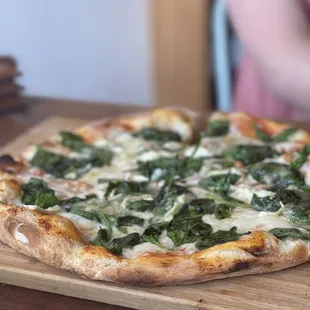 a pizza with cheese and spinach