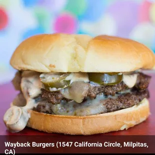 a hamburger with cheese and pickles