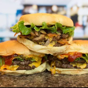 three cheeseburgers stacked on top of each other