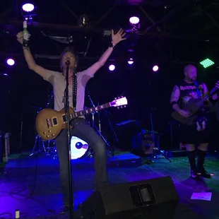 a man on stage with his arms in the air