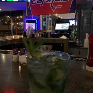 a glass of cocktail on a bar