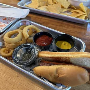 Greasy, under cooked onion rings, a hot dog, and gas station queso with chips.