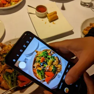 a person taking a picture of a plate of food