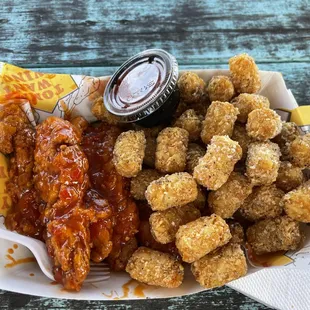 a basket of fried chicken and tater tots