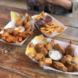 two baskets of chicken wings and fries