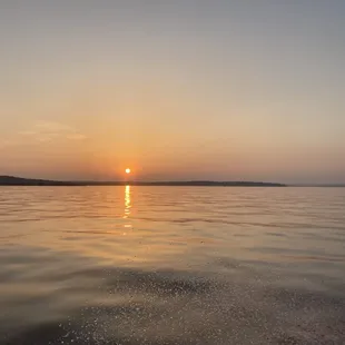 the sun setting over the water