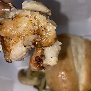 a hand holding up a piece of chicken
