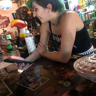 a woman sitting at a bar looking at her cell phone