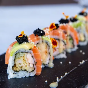 a sushi roll with salmon, avocado, and cavia