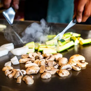 a chef chopping mushrooms and zucchini