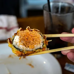 a person holding chopsticks over a plate of food