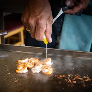a person cooking food on a grill