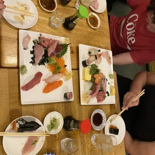 Sushi Sashimi Deluxe plus on my plate a salmon skin roll and across the table my sis had an Ikura sushi
