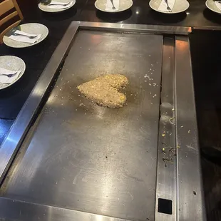  a hot plate with a piece of meat on it