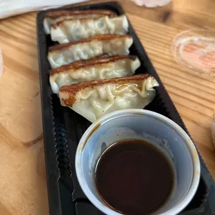 a plate of dumplings and dipping sauce