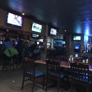 people sitting at the bar watching tvs