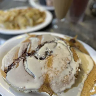 a plate of pancakes with cream and syrup