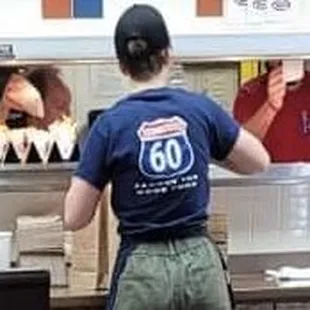 Dude free handing all side orders on the left and the cook on the right.. no gloves. At least the woman in the photo had gloves on. ‍