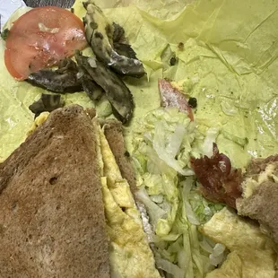 an omelet, lettuce, and tomato sandwich