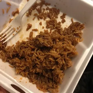 a fork and rice in a styrofoam container