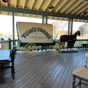 a covered porch with a horse drawn wagon