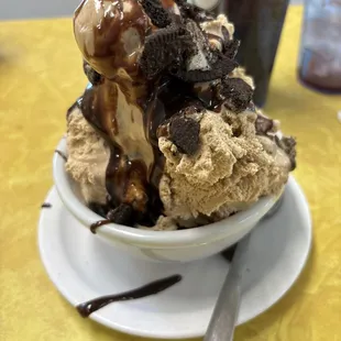 Three scoop sundae with caramel brownie ice cream and hot fudge with oreos