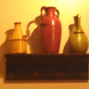 three vases on a shelf