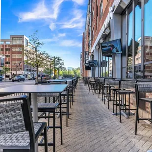 empty tables and chairs on the sidewalk