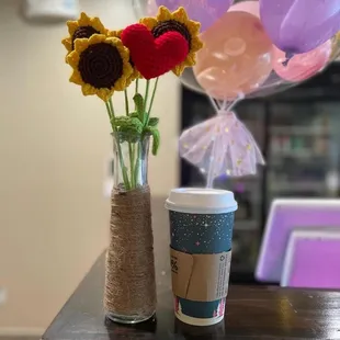 a cup of coffee and a bouquet of sunflowers