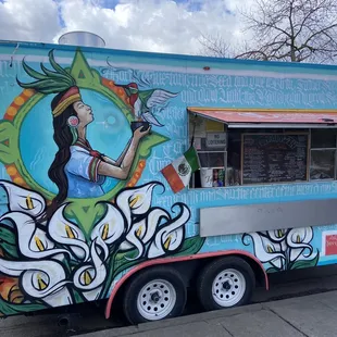 a colorful food truck parked on the side of the road