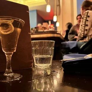 a glass of water and a lemon slice on a table