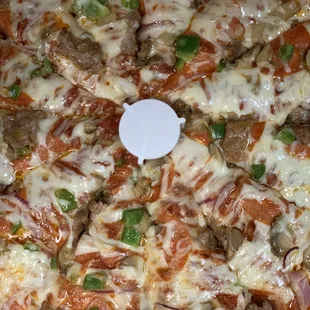 a pizza with meat, cheese, peppers, and onions