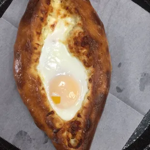 a piece of pizza with an egg in the middle