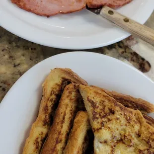 a plate of french toast and ham