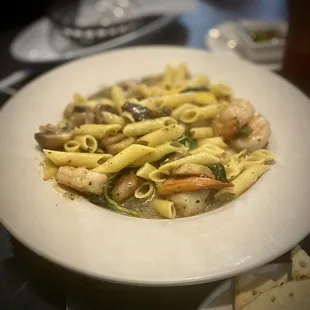 a plate of pasta with shrimp and mushrooms