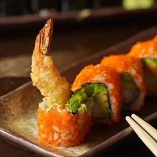 a plate of sushi and chopsticks