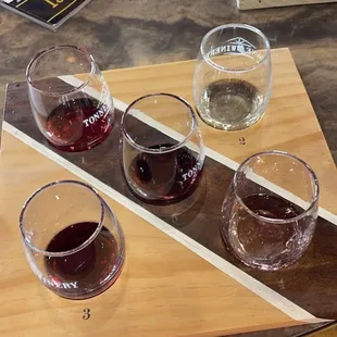 four glasses of wine on a cutting board