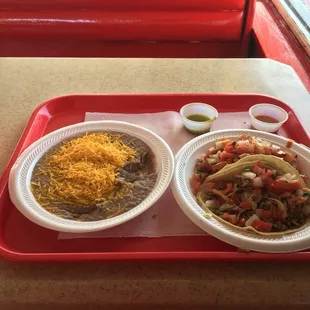 Frijoles and two tacos de carnitas