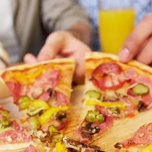 a person holding a slice of pizza