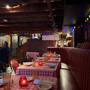a dining area with red and white checkered tablecloths