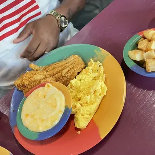 a plate of fried chicken, eggs, and hash browns