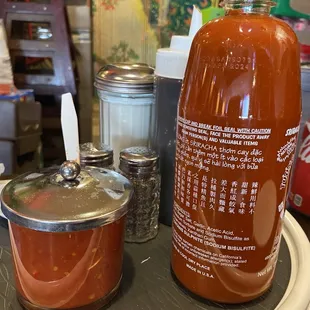 a bottle of hot sauce and a saucer