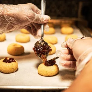 a person putting jam on a cookie