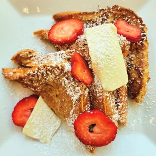 a plate of french toast with strawberries and bananas