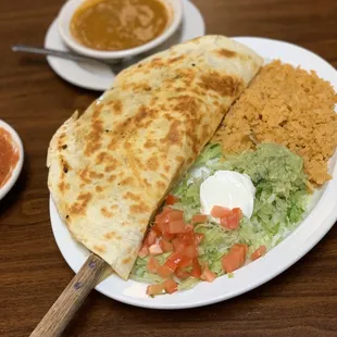 The quesadilla is half the size of the plate.