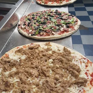 three pizzas on a counter