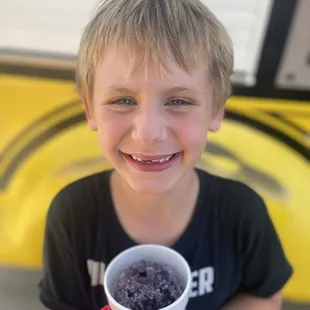 a young boy holding a cup of ice cream