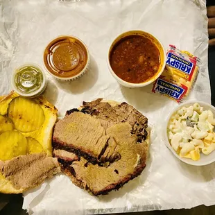 shows a meat sandwich, macaroni and cheese, and a side of macaro